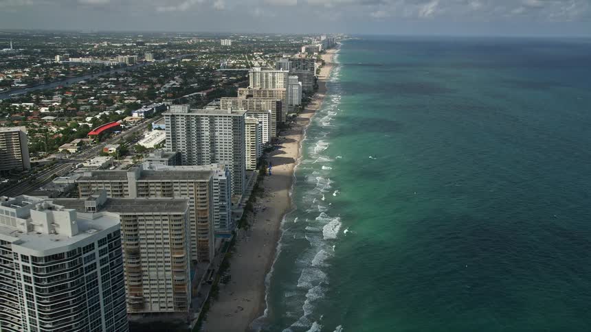 An aerial view of apartment buildings and shoreline revealing a beautiful beach and coastline in Fort Lauderdale Florida