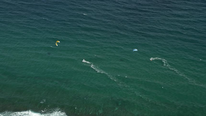 A thrilling aerial view of kite surfers catching waves off Hillsboro Beach Florida on a sunny day