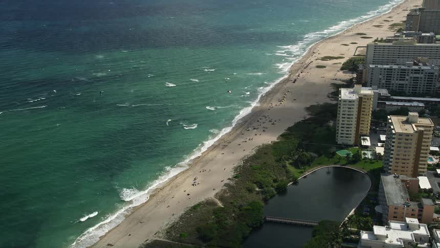 Aerial footage of kite surfers circling around near the coastline of Pompano Beach Florida