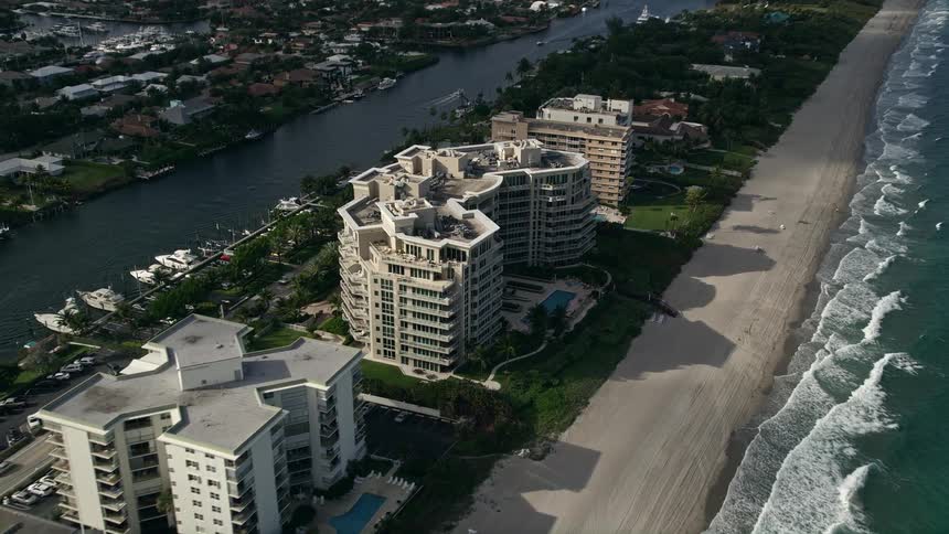 The aerial footage captures the beautiful shoreline of Hillsboro Beach Florida as it tilts down to reveal the stunning condominium complex nearby