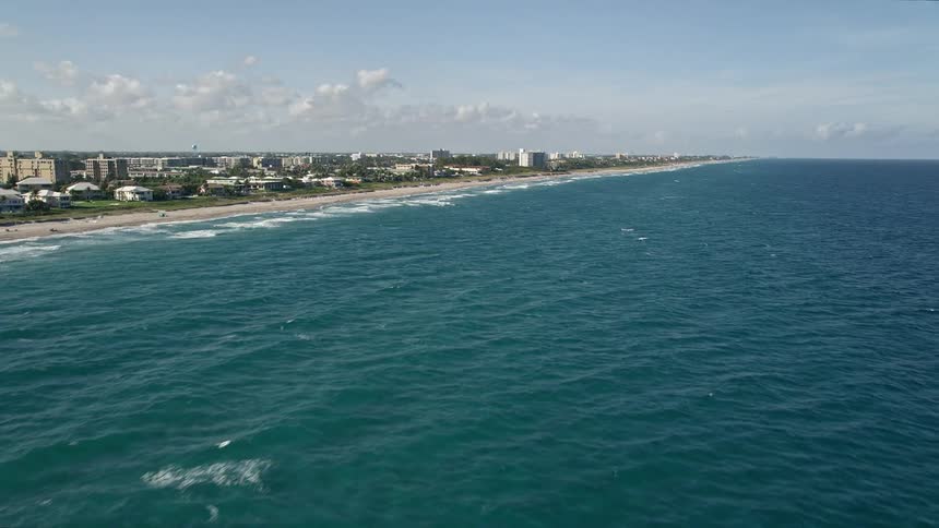 A stunning aerial view of the shoreline in Highland Beach Florida showcasing the ocean waves coast line and residential buildings