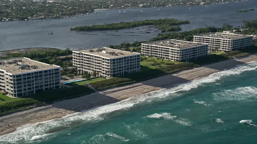 Fly above the beautiful coastal condominium complexes along Palm Beach Island offering stunning views of the shoreline and oceanfront property