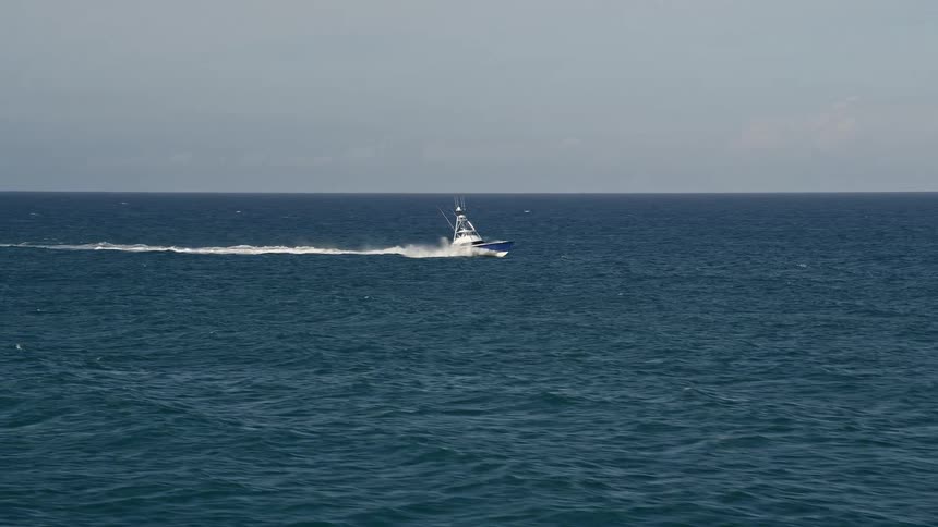 A fishing boat is filmed from the air cruising across the Atlantic ocean off Jupiter Florida during a partly cloudy day