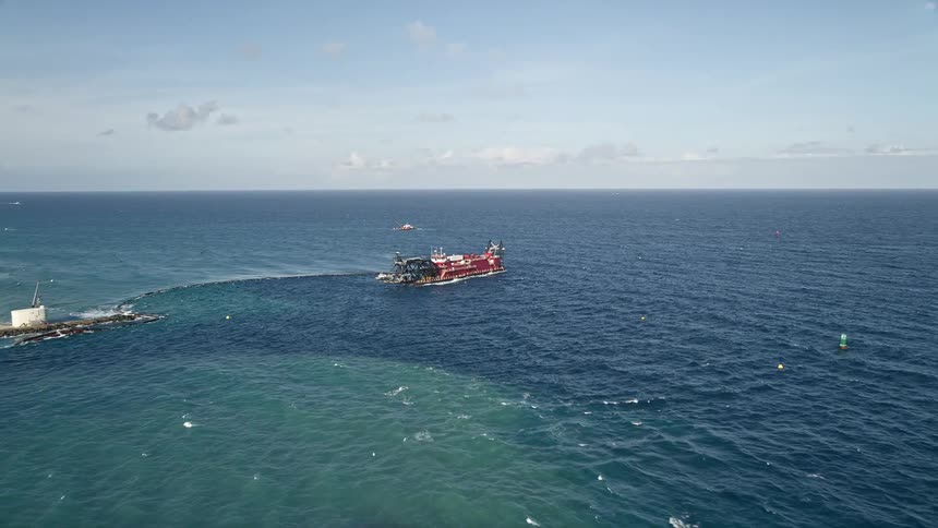 Approaching and orbiting a dredging ship near Palm Beach Shores Florida in daytime aerial footage