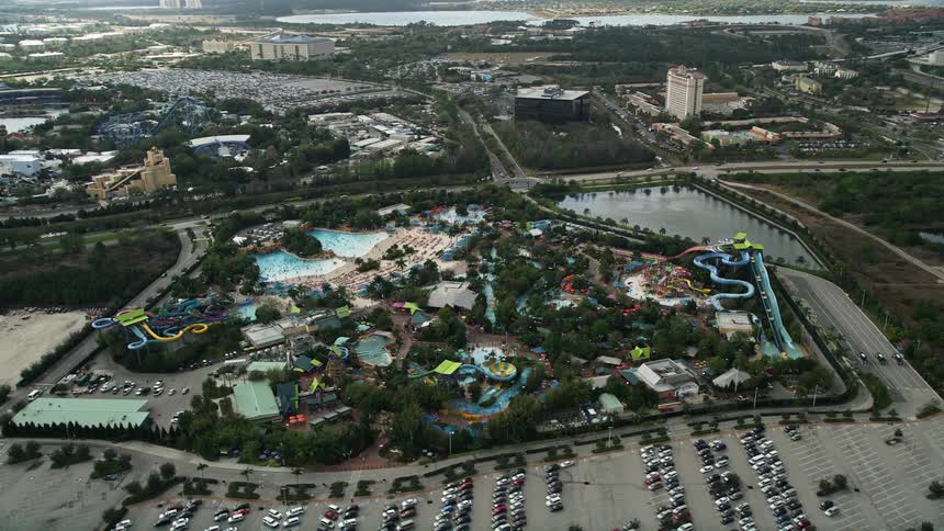 Viewers get a sweeping birds-eye view of Aquatica Florida a water park in Orlando Florida with partly cloudy skies and busy crowds enjoying summertime recreation