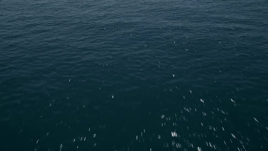 Aerial footage of low flying over the crystal blue ocean waters of Malibu California