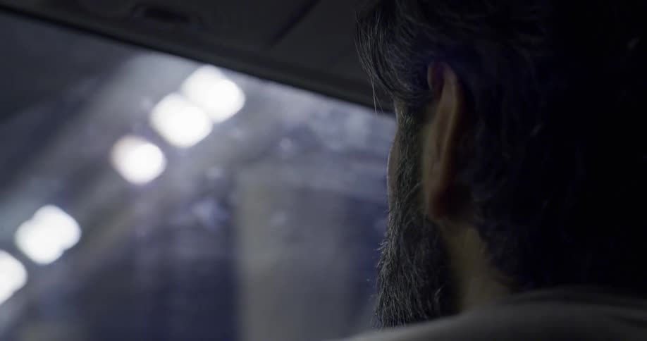 Man in the passengers seat of a car driving through a lit up tunnel