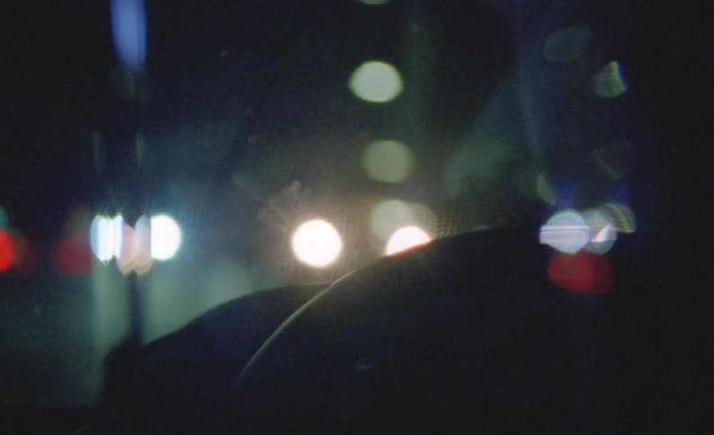 A close up of a person driving a car at night the inside of the car dark