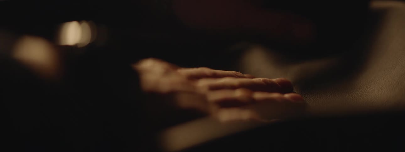 Close up of the hands of a craftsman using his hands to flatten a piece of leather over a table