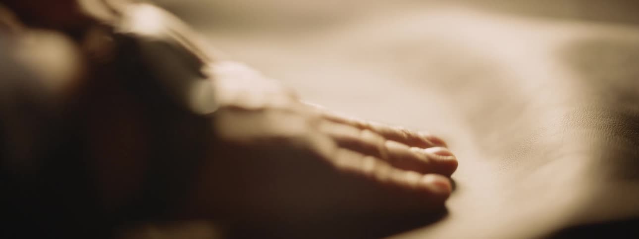 A hand engaged in the task of smoothing a cloth on a table