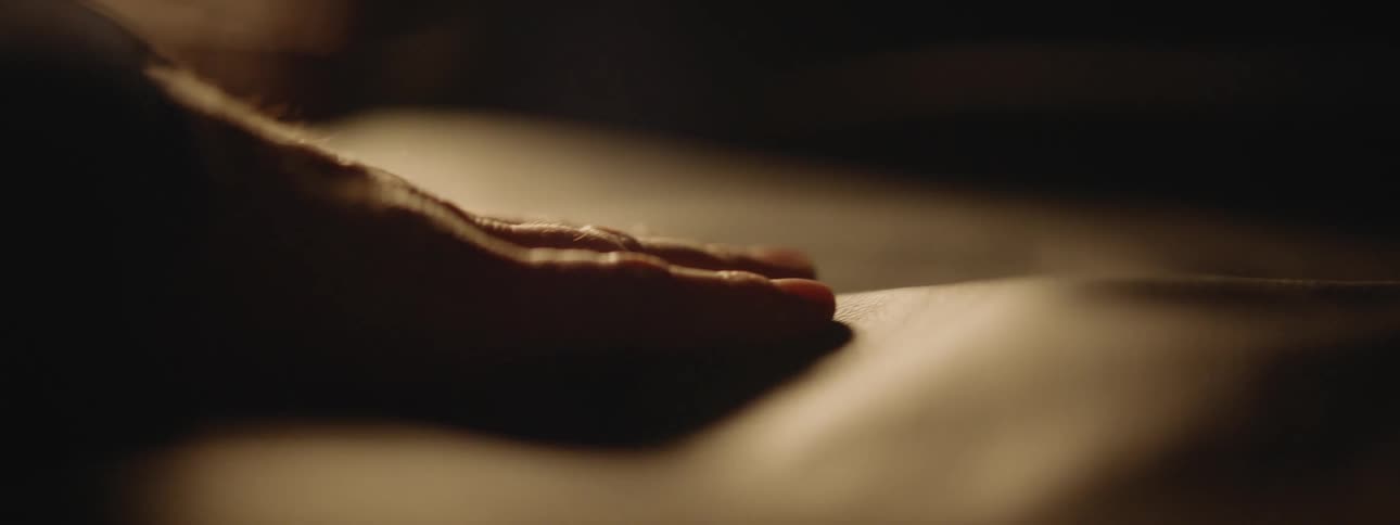 A close up of a persons hand touching a leather like material