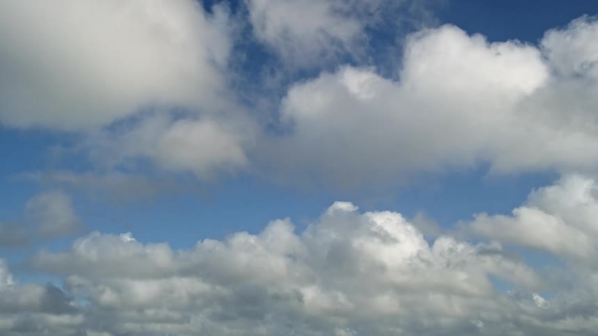 Aerial footage of white cumulus clouds floating across the blue sky over the Florida Everglades