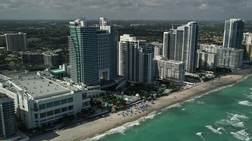 A beautiful aerial view of The Westin Diplomat Resort and Spa in Hallandale Beach Florida surrounded by tall buildings and people enjoying themselves on the beach