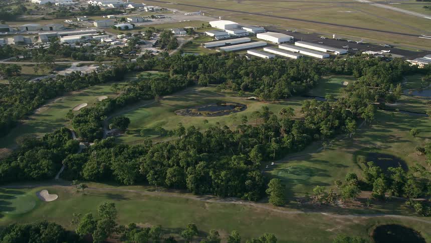 Aerial view of the Martin County Golf and Country Club tilting down to a pond during a partly cloudy dusk in Stuart Florida