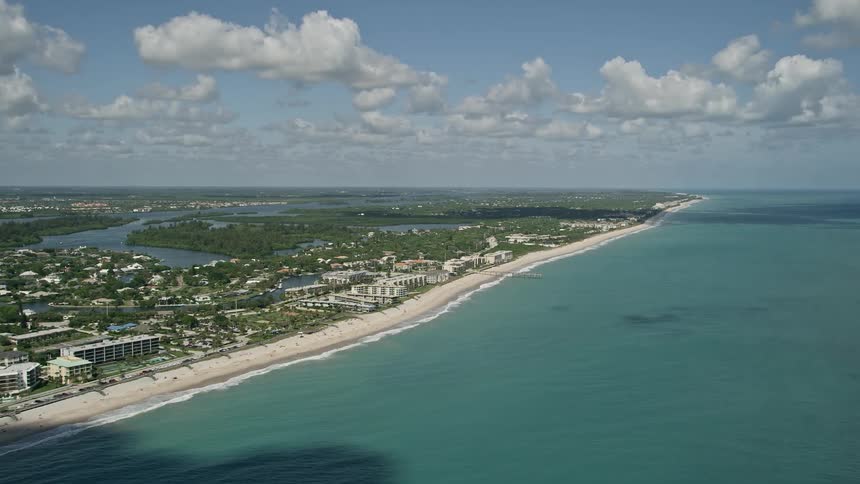 A sunny day aerial view of a populated beach community in Vero Beach Florida as waves crash against the shore