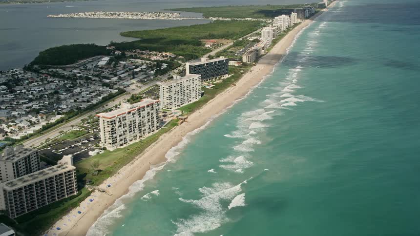 A stunning aerial view overlooking the condominium and apartment complexes by the beach in Jensen Beach Florida with roads weaving through the residential neighborhood between the water borders