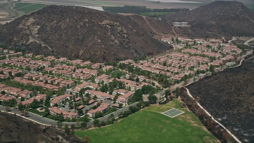 Approaching condominiums and duplex homes in a Southern California neighborhood at the base of hills