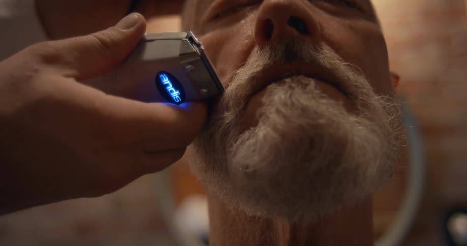 A man is having his beard trimmed