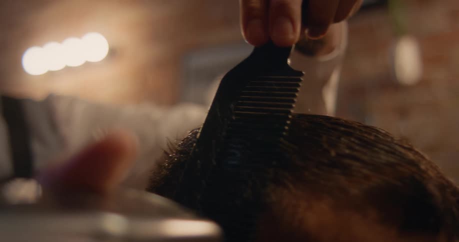 Close up of the hands of a hairdresser giving a customer a haircut