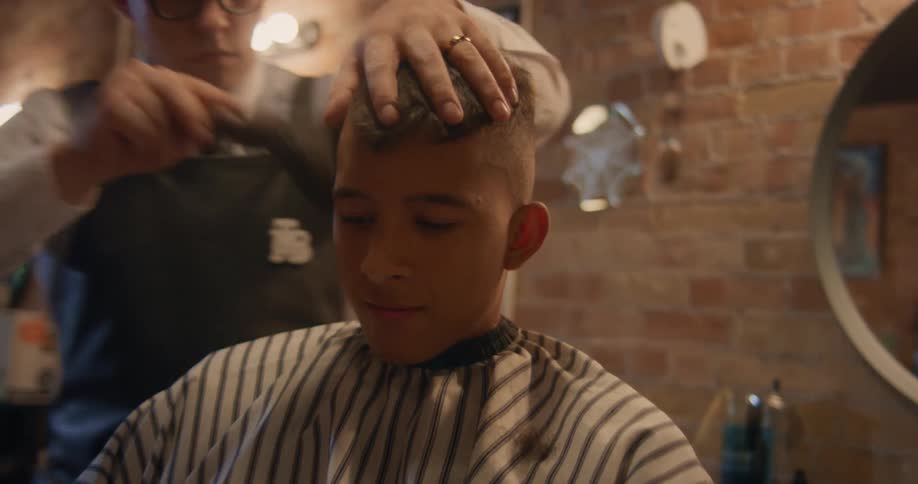A barber brushes stray hair off a clients face and neck