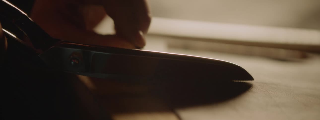 A person is cutting a sheet with scissors