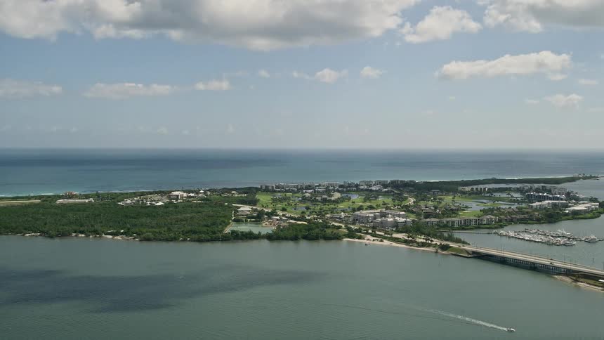 A birds eye view footage of Hutchinson Island and Stuart in Florida connected by a bridge over a waterway during summer