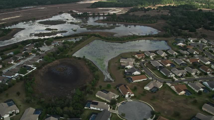 A stunning aerial flyby of a residential neighborhood surrounded by wetlands and ponds in Clermont Florida