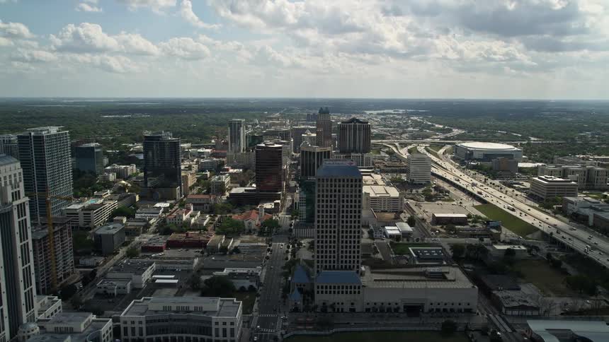 Aerial view of Downtown Orlando Florida with a courthouse office tower and freeway surrounded by a metropolis during the daytime