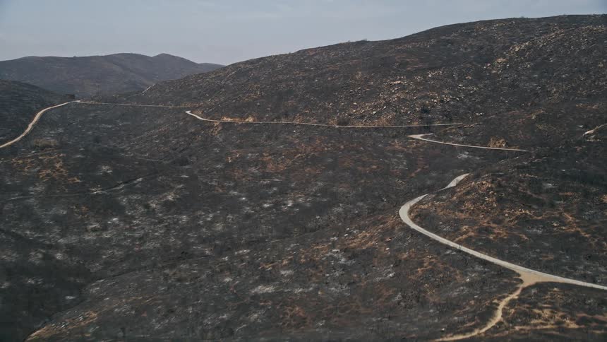 Aerial footage of a mountain road winding through the fire-damaged slopes of Santa Monica Mountains in California