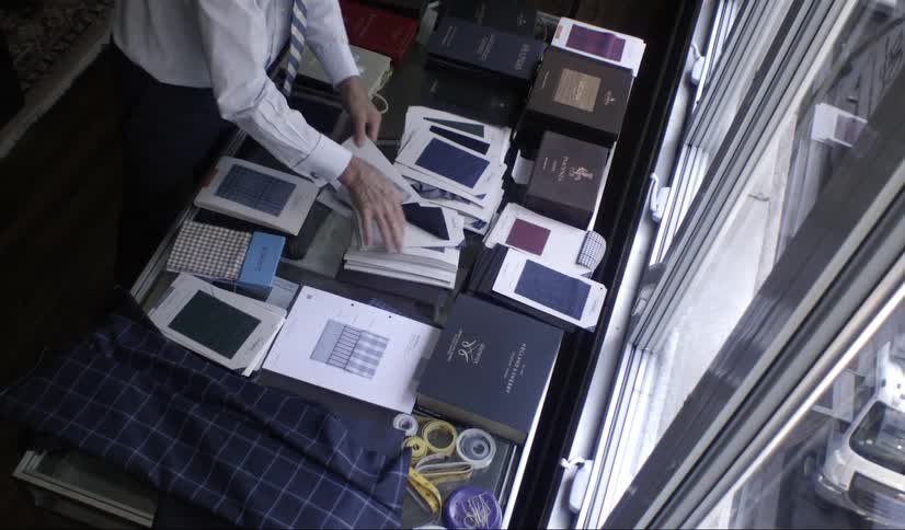 Office worker arranges brochures on a desk near a window in the office