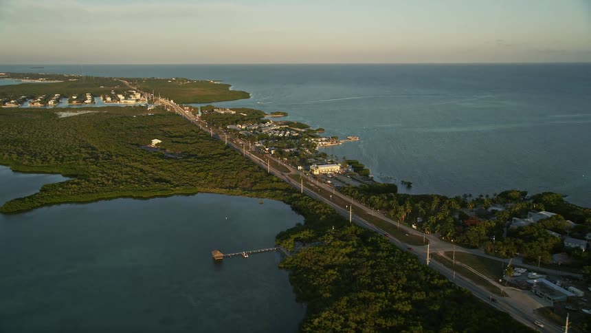 Aerial view of cars driving along the narrow Overseas Highway by Drop Anchor Resort and Marina in Islamorada Florida during a beautiful sunset
