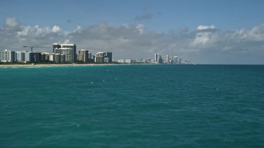 Aerial footage of flying over Sunny Isles Beach Florida revealing beachfront high rise towers and coastline on the Atlantic Ocean