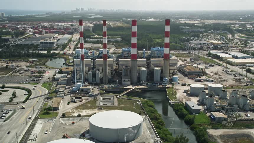 Approaching Port Everglades Plant in Fort Lauderdale Florida seen from an aerial with smoke stacks and industrial dockyards visible