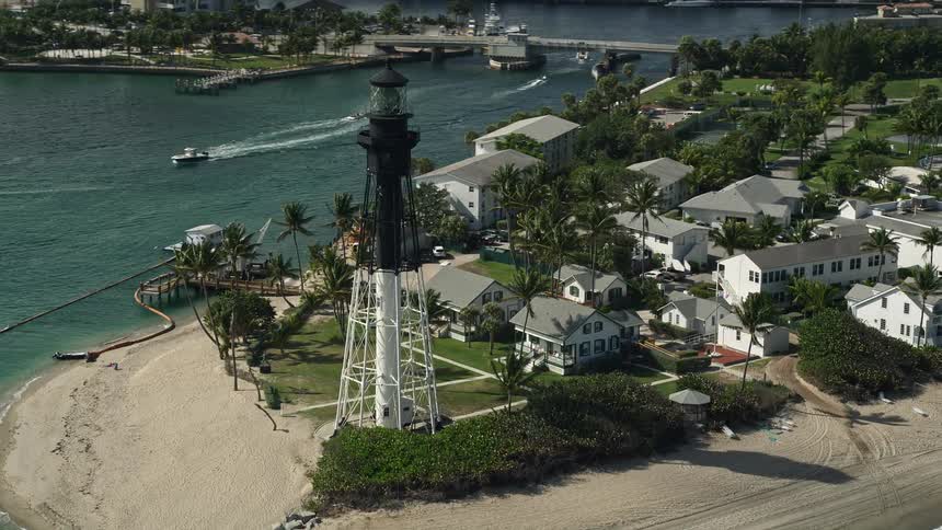 Aerial view of Hillsboro Inlet Light a famous lighthouse on Hillsboro Beach Florida with people enjoying the beach and coastline