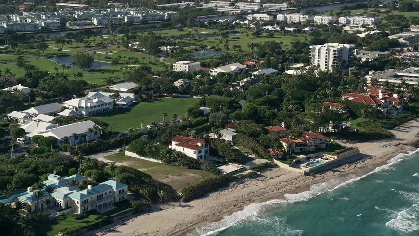 Flying over luxurious beachfront homes and their pools along the Gulf Stream coast of Florida showcasing the upscale neighborhoods and coastal communities
