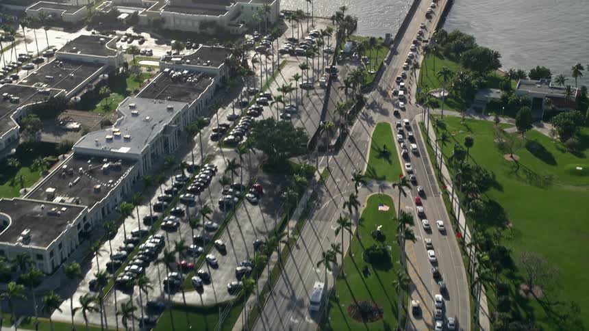 An aerial view of heavy traffic crossing the Flagler Memorial Bridge that reveals the marina near Royal Poinciana Way in Palm Beach Florida