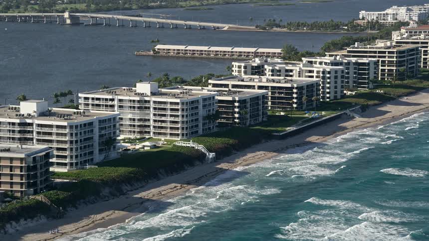 A stunning aerial view of Palm Beachs condo-lined coastline as waves crash against the shore