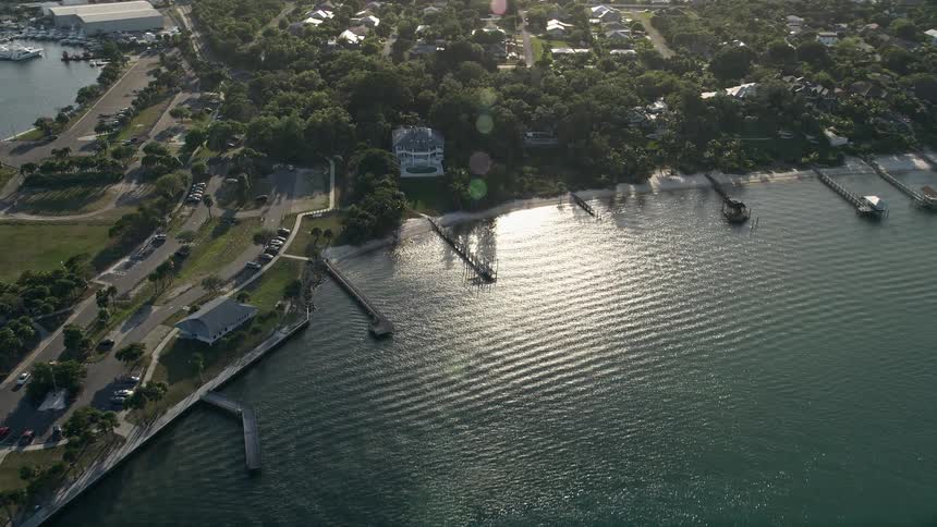 Aerial view of a coastal town as it approaches a house by Sandspirit Park during dusk in Stuart Florida