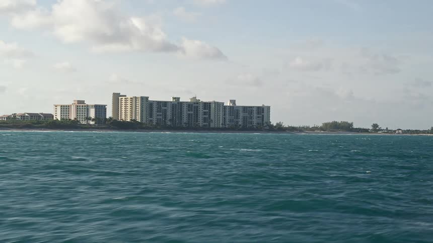 Flying low over the Atlantic Ocean near condo complexes in Jupiter Florida capturing the beautiful shoreline and the residential condominium buildings from a low altitude