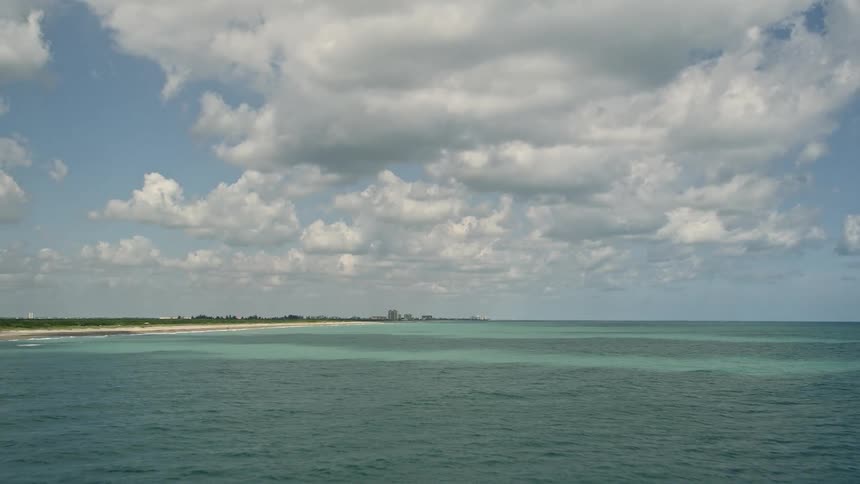 Approaching the beautiful shorelines of Fort Pierce on the east coast of Florida during a partly cloudy day through an aerial 