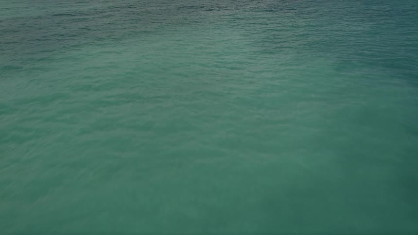 An aerial view of the blue Atlantic Ocean waters off the coast of Florida during a partly cloudy day