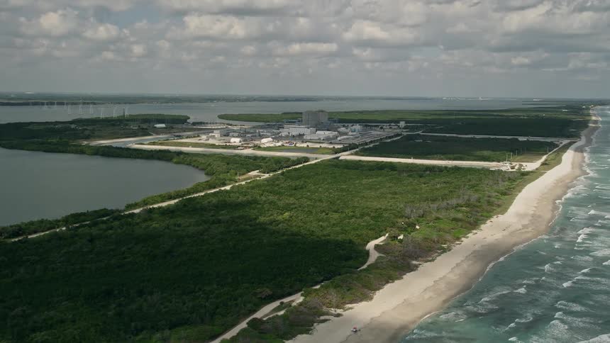 Approaching view of St Lucie Nuclear Power Plant on a partly cloudy day from an aerial in Florida