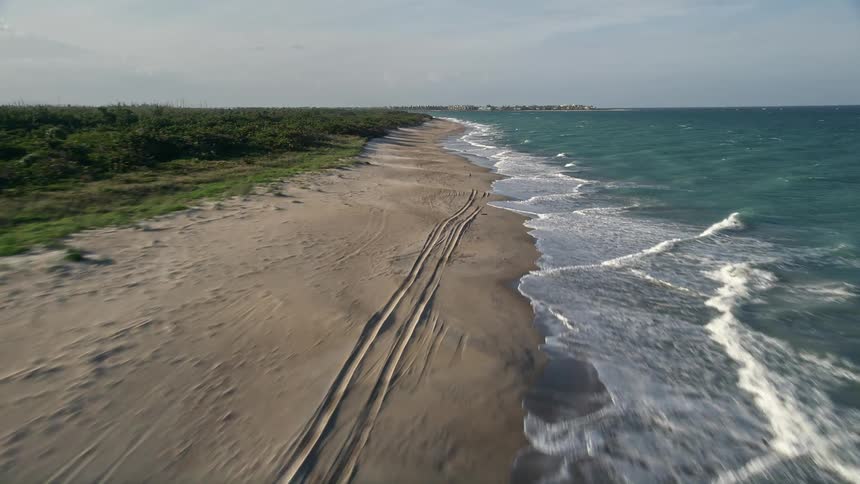 A low flying aerial view of the coastline at Saint Lucie Inlet Preserve State Park Stuart Florida on a partly cloudy day during the spring or summer
