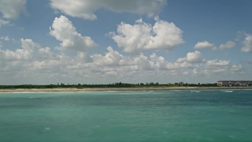 Aerial footage of coastal apartment buildings alongside a beautiful shoreline in Fort Pierce Florida