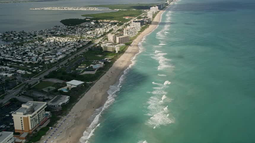 Stunning aerial views of the condominium and apartment complexes along Jensen Beachs shoreline with plenty of beachgoers soaking up the sun in this 5K footage captured during daylight hours in Florida!
