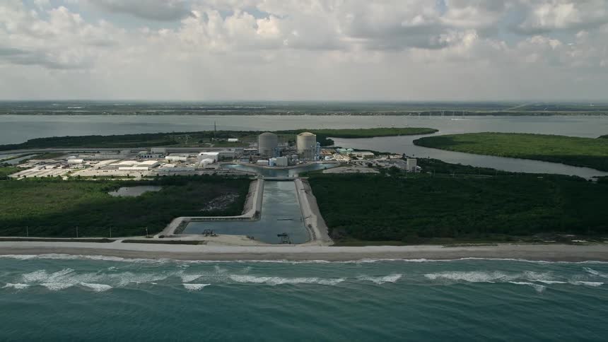 Aerial view of St Lucie Nuclear Power Plant over the ocean Florida on a partly cloudy day