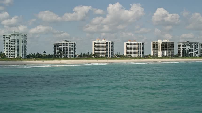 A low-altitude aerial view of beachfront apartment buildings and coastline in Fort Pierce Florida
