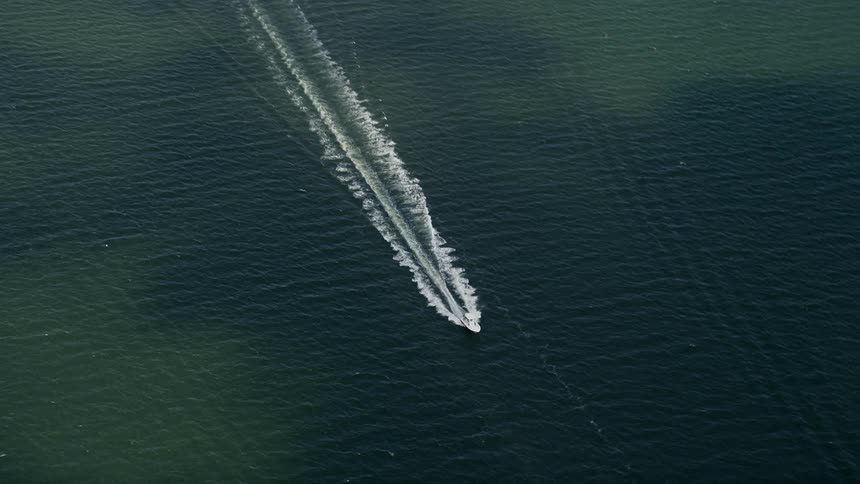 A fishing boat approaches Melbourne Beach Florida in this aerial footage captured during a partly cloudy day in summer