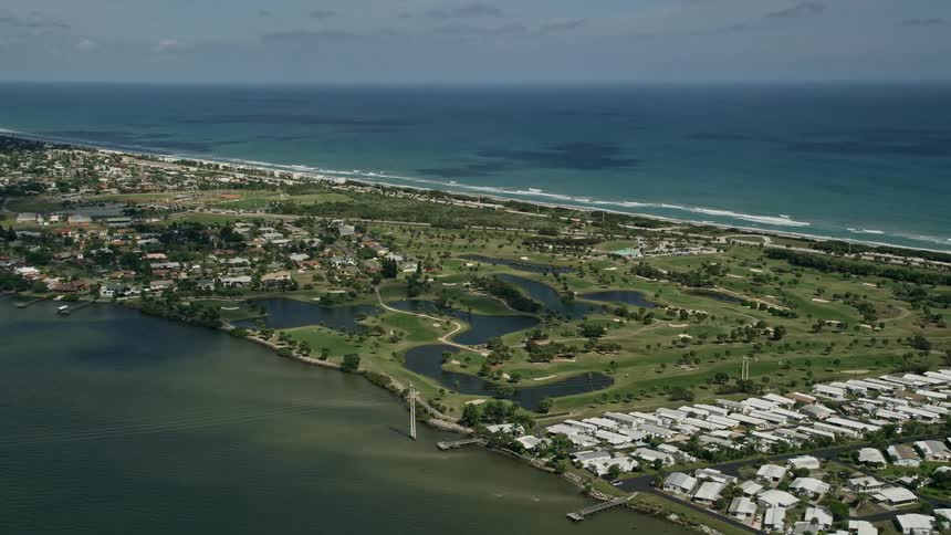 A stunning aerial view of Spessard Holland Golf Course next to the river in Melbourne Beach Florida on a partly cloudy day