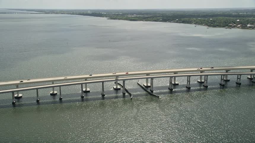 Aerial footage of cars crossing a causeway in Merritt Island Florida on a partly cloudy day